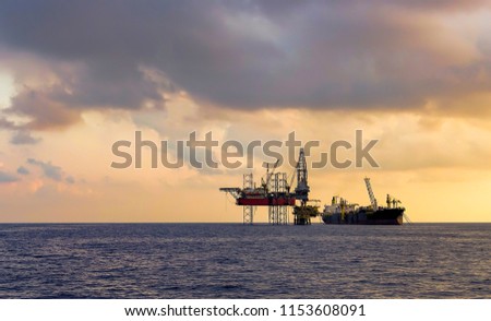 FPSO ship and drilling rig on oil production platform in offshore oil field with beautiful cloud and blue sky background