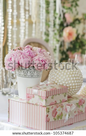 decoration of wedding table. flowers in vase with gift boxes that stand on each other and ball