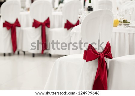 White banquet chair with a red bow in the banquet hall