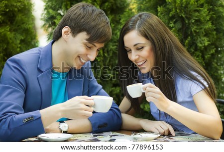 Young couple sitting at the table and drink coffee
