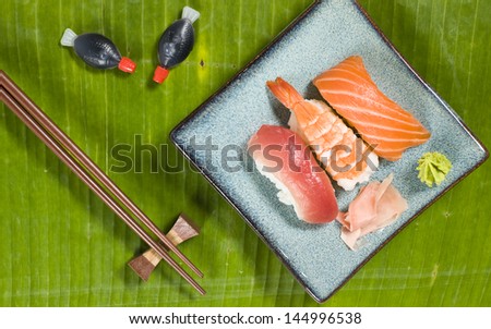 Sushi assorted plate, prawn, salmon and tuna with ginger and wasabi on banana leaf