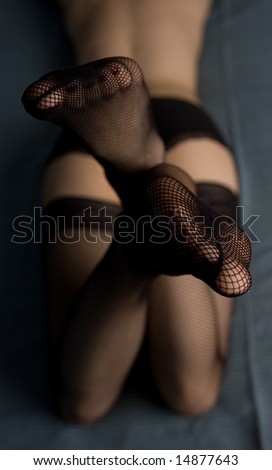 Close-up shot of female legs in open-work stockings
