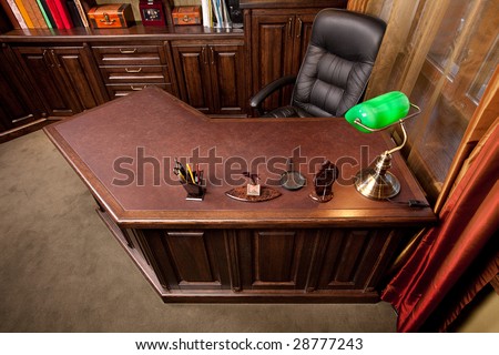 Old style home office with leather armchair and green lamp