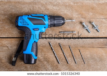 Close up Electric drill, Drill set, Screwdriver set, adapter on wooden table background and copy space. Hammer drill or screwdriver, Electric cordless hand drill on wooden.  maintenance home concept.