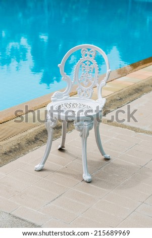 White steel chair in classic style placed beside the pool