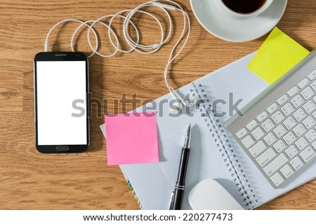 Office table with notepad, computer, coffee cup , computer mouse , pen , smartphone , headphone , sticky notes. View from above with copy space