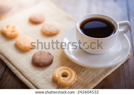 Cup of coffee and Many shapes biscuit on sackcloth and wooden table