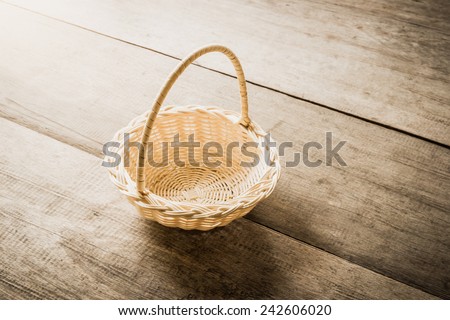 Empty wicker basket isolated on wooden table background