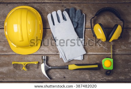 Standard construction safety equipment and Tools on wooden table. top view