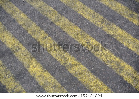 Yellow stripes painted texture on asphalt