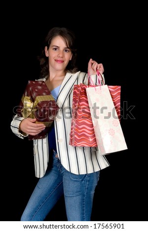 Happy young woman with shopping bags and present, black background, studio shot