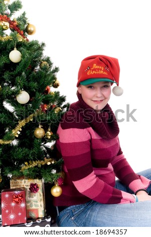 Happy girl by the Christmas tree on white background