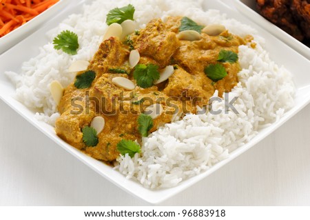 Curry meal - lamb pasanda with rice, bhaji and carrot salad behind.