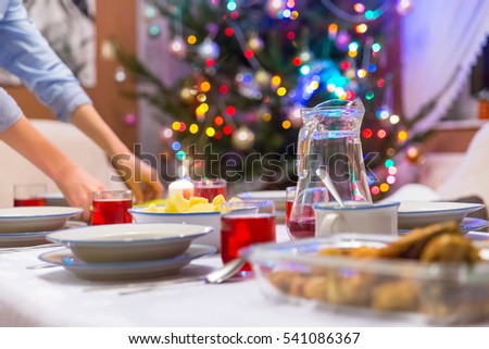Family preparing food on the table for dinner at the night of Christmas. We eat together traditional polish fish, talking and having fun. After the dinner we are opening presents from Santa Claus.
