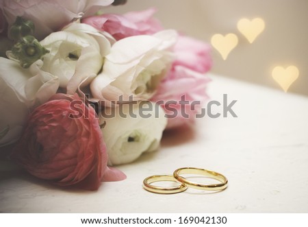 Wedding invitation. Flowers with wedding rings on vintage table