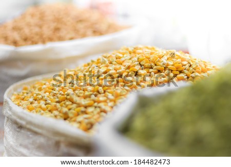 Corn seeds and other grains in bags on oriental market isolated on white