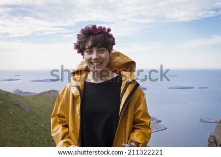 Traena, Norway - July 12 2014: portrait of a young woman with a yellow rain coat before the concert of the Norwegian Singer Stein Torleif Bjella on Sanna Island at the Traena music festival