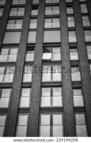 High storey building with windows and a bed cover hanging and drying