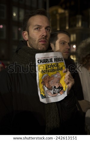Amsterdam The Netherlands January 08 2015 demonstation in solidarity with Charlie Hebdo in Paris France on 07 January A man holds an issue of Charlie Heddo where it says Love stronger than hate Amsterdam The Netherlands January 08 2015 demonstation in solidarity with Charlie Hebdo in Paris France on 07 January A man holds an issue of Charlie Heddo where it says Love stronger than hate