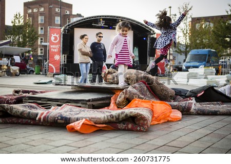 Amsterdam, The Netherlands, 12-14 Septembre 2014, during West\'ival, an open air free Cinema and culture festival on Mercatorplein. Children playing on the square before the screening starts