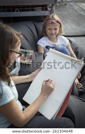 Amsterdam, The Netherlands, 12-14 September 2014, at West\'ival, a free open air Cinema and culture festival on Mercatorplein. artist sketching a little girl