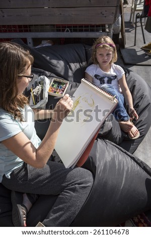 Amsterdam, The Netherlands, 12-14 September 2014, at West\'ival, a free open air Cinema and culture festival on Mercatorplein. artist sketching a little girl
