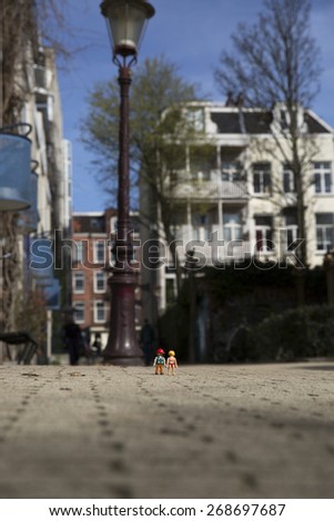 Amsterdam, the Nertherlands. April 12, 2015. Man and woman walking together after a day in the park. Playmobil toy line exist since 1975 and is produced by the German company Brandtaetter.