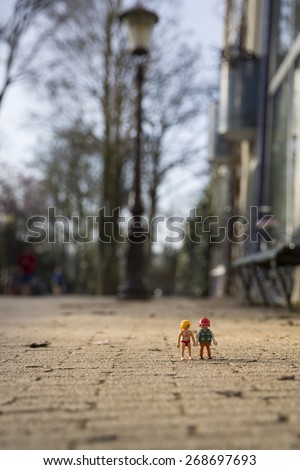 Amsterdam, the Nertherlands. April 12, 2015. Man and woman walking together after a day in the park. Playmobil toy line exist since 1975 and is produced by the German company Brandtaetter.