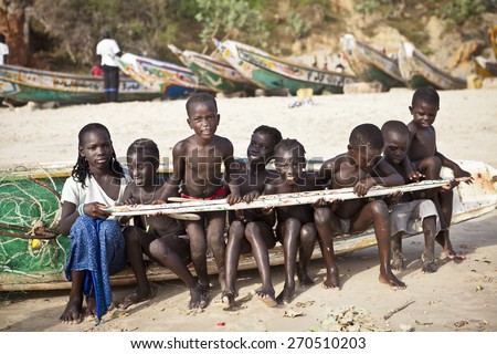 SENEGAL, Ndayane - November 9, 2013: Senegalese children on the beach of Ndayane, playing and waiting for their father to come back from fishing. Despite poverty, Senegal kids stay smiling.