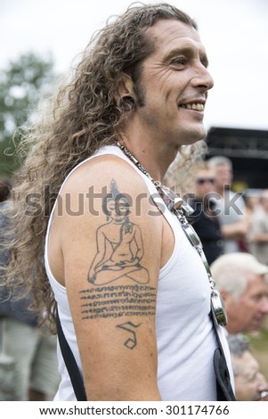 Amsterdam, The Netherlands - July, 5 2015: man with long grey hair and indie tattoo during Amsterdam Roots Open Air, a cultural festival held in Park Frankendael on 05/07/2015