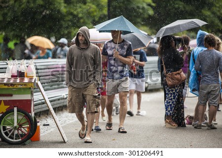 Amsterdam, The Netherlands - July, 5 2015: visitors walking under the rain during Amsterdam Roots Open Air, a cultural festival held in Park Frankendael on 05/07/2015