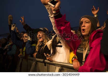 Traena, Norway - July 9 2015: fans cheering with arms up at concert of Norwegian rock band OnklP & De Fjerne Slektningene at Traenafestival, music festival taking place on the small island of Traena