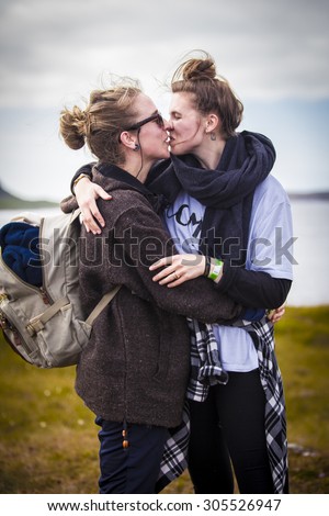 Traena, Norway - July 11 2015: two young women kissing during the smallest gay Pride in Europe during Traenafestival, music festival taking place on the small island of Traena.