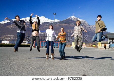The group of jumping people on a background of mountains