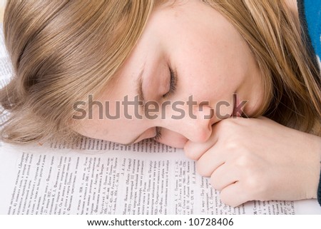 The young tired student sleeps on books