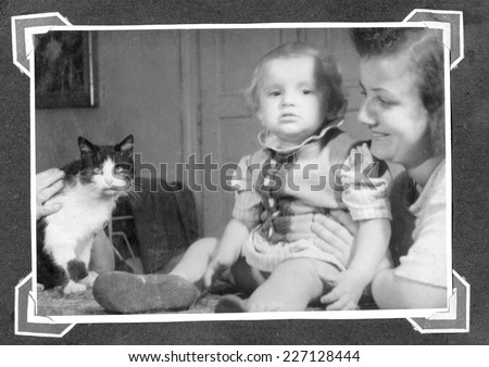 KROSNO,POLAND - CIRCA 1947:vintage photo of baby girl,her mother and cat