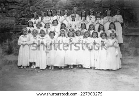 JASLO,POLAND - CIRCA 1959: vintage photo of girls reciving First Holy Communion and ther priest teacher