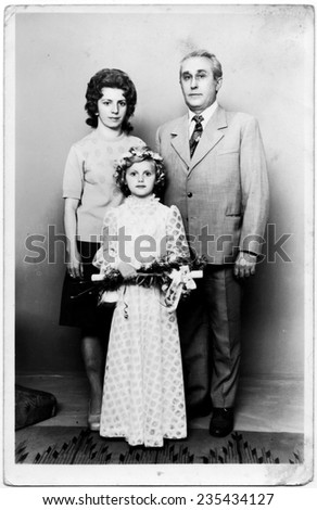 RADOM,POLAND - CIRCA 1955 : vintage atelier photo of parents and daughter receiving Holy Communionman