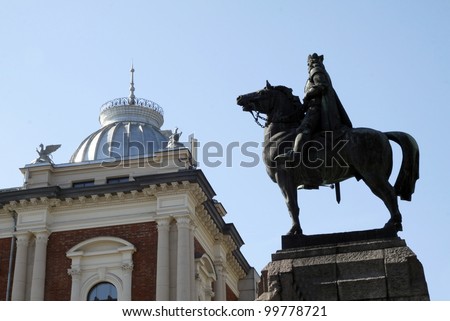 fragment of monument and small horses on the roof of building