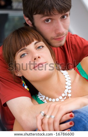 Young relaxed teenagers sit together and look towards