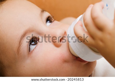 Small boy face drinking milk from a bottle