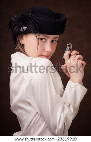 Young girl is holding a toy pistol in hands