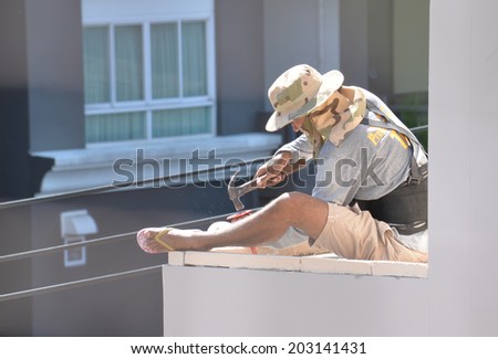 BANGKOK THAILAND - JUL 6 : An unidentified man worker work on high building  on JUL 6, 2014 in Bangkok, Thailand