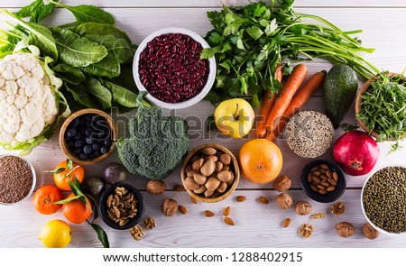 Healthy food clean eating : fruit, vegetable, seeds, superfood, cereals, leaf vegetable on black wood background with copy space, top view.