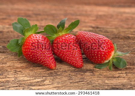 Fresh red ripe whole strawberries on old rustic look timber