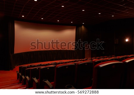 Empty red cinema room/interior with white screen and seats. Side view