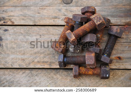 Old bolts or dirty bolts on wooden background, Machine equipment in industry work.