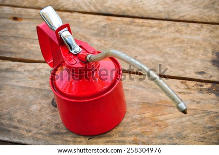Oil can on wooden background, Lube oil can and used in industry or hard works.