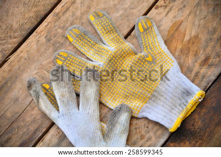 Old safety gloves on wooden background, Gloves on dirty works.