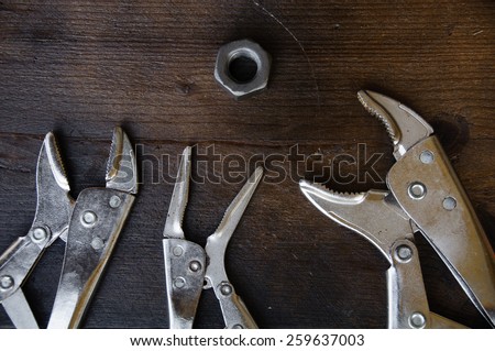 close up locking pliers on wooden background, Hand tools in work shop.